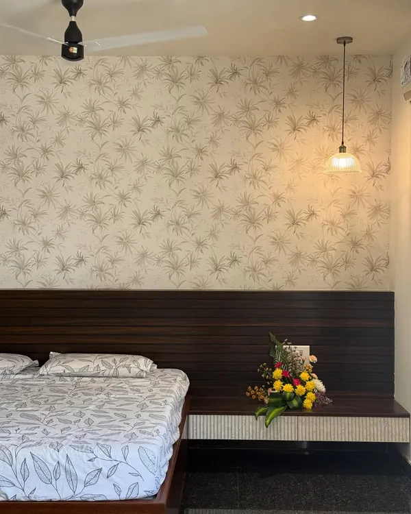 When your wallpaper whispers ‘calm,’ but your pendant screams ‘center of attention’. A lovely bedroom design balancing subtle patterns with a statement light.
