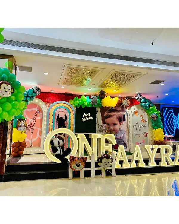 Welcome to the jungle! This is one of my favorite setups, showing a complete stage decoration for a jungle safari theme. I use large marquee letters, custom backdrops, and plenty of animal props to create an immersive world for your child's big day.