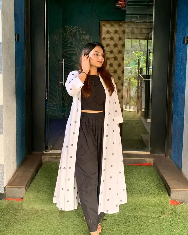 A chic and professional look featuring a custom-made co-ord set with a mul cotton jacket. The black crop top and pants are paired with a block-printed long jacket for a stylish statement.
