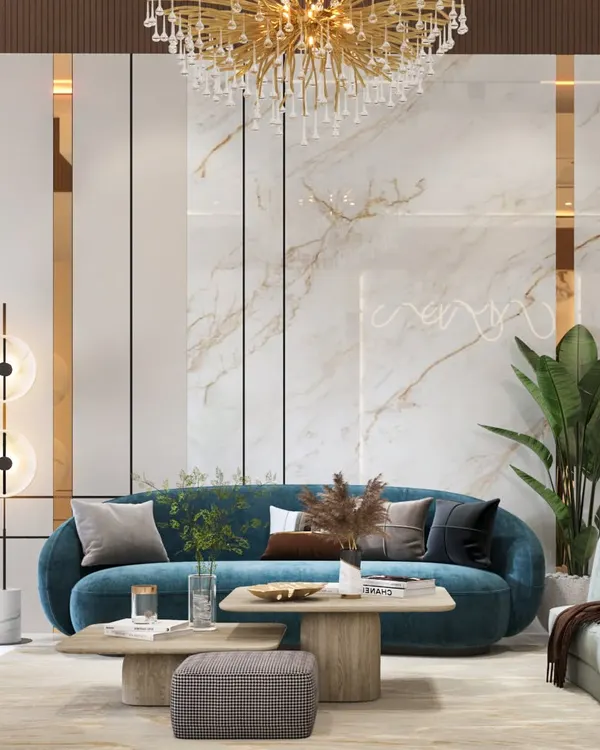 This living room is a masterclass in using accent colors. A bold teal sofa is the centerpiece, set against a backdrop of white marble, gold accents, and a stunning statement chandelier, creating a look of pure luxury.