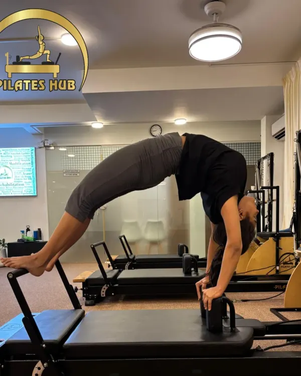Here I am demonstrating a full back bridge on the Pilates Reformer. This advanced movement showcases the incredible spinal articulation and core strength you can develop through consistent practice.