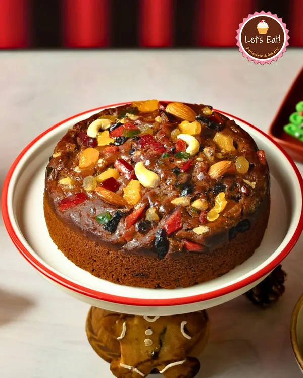 My signature Christmas Plum Cake, generously topped with candied fruits and nuts. This traditional cake is the centerpiece of any holiday celebration.