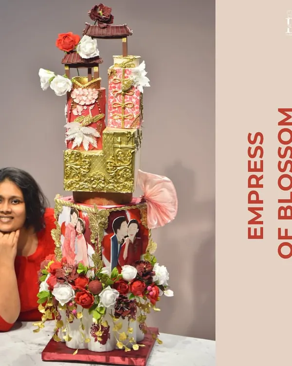 Here I am with the 'Empress of Blossom,' one of my most ambitious wedding cake projects. Standing tall, this cake combines marble textures, edible gold, and symbolic flowers to bless the couple with a loving and prosperous future.