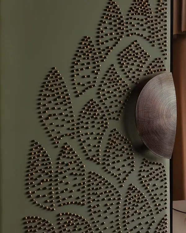 A close-up of the custom-designed door handle and the 3D embellished fabric of the entrance. The half-round brass handles meet at the center of the floral motif, anchoring the piece with a detail that is both functional and symbolic.