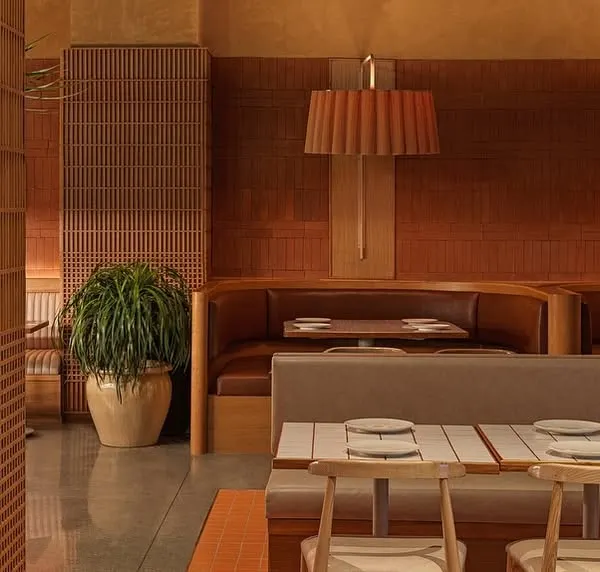 This wide view of Biergarten showcases how we used different seating arrangements, from booths to tables, to break up the large space. The consistent use of natural materials and warm lighting ties everything together into a cohesive, inviting environment.
