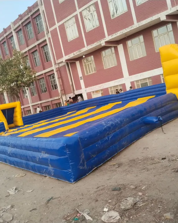 This is an inflatable soapy football court with a yellow and blue striped floor. It's a huge space, perfect for a 5-a-side game.