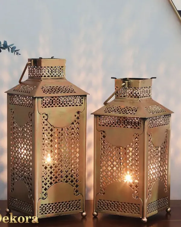 These Moroccan-style metal lanterns feature intricate latticework that casts beautiful, complex shadows when lit. Available in two sizes, they are perfect for adding an exotic and warm ambiance to a patio or living room.