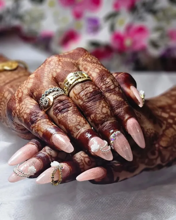 A close-up of one of my favorite bridal sets. The combination of soft pink, 3D white roses, and delicate silver and gold chains creates a look of pure elegance that beautifully complements the bride's henna.