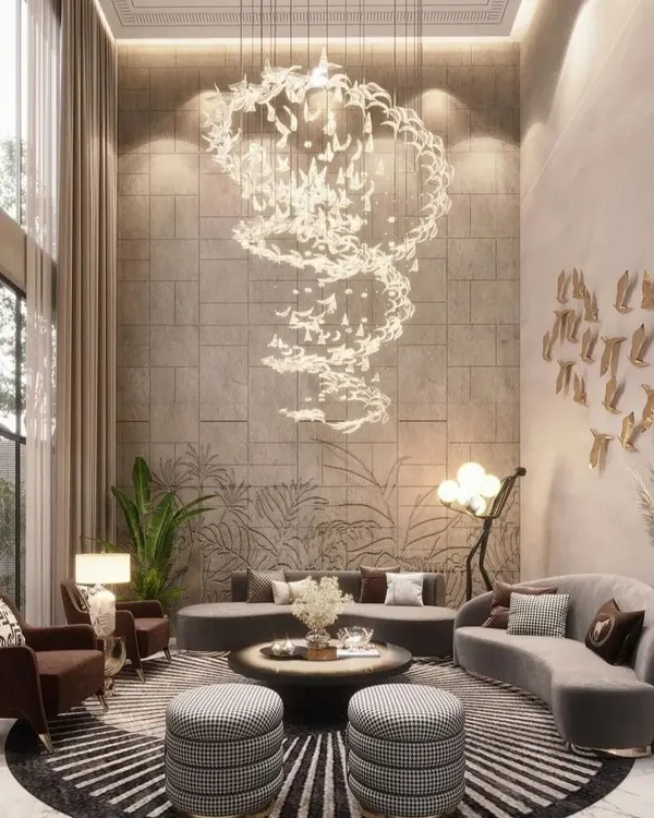 We craft double-height living rooms that are the epitome of grandeur and luxury. This space features a breathtaking custom spiral chandelier that cascades through the open volume, complemented by nature-inspired wall art and plush, curved seating, creating an unforgettable statement of high-end residential design.
