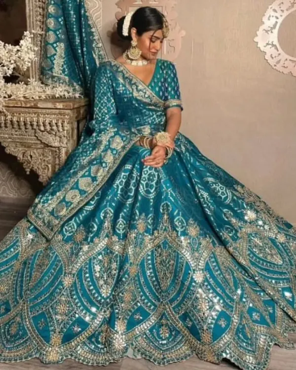 This is the look that turns heads. A magnificent teal banarasi lehenga paired with a traditional gold-plated choker, matching jhumkas, and a delicate maang tikka. I make sure you get the complete royal look for your special day.
