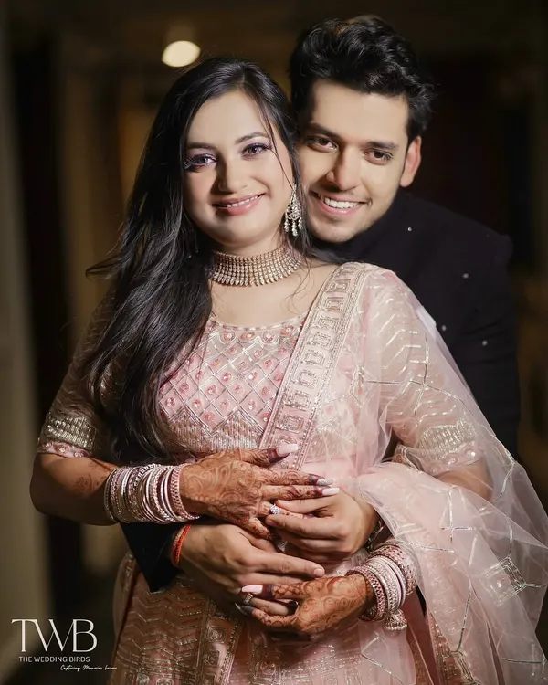 A warm, happy hug from behind. This portrait from an engagement shoot shows the couple's joy and comfort with each other. Her beautiful lehenga and his classic bandhgala are captured with a focus on their happy expressions.