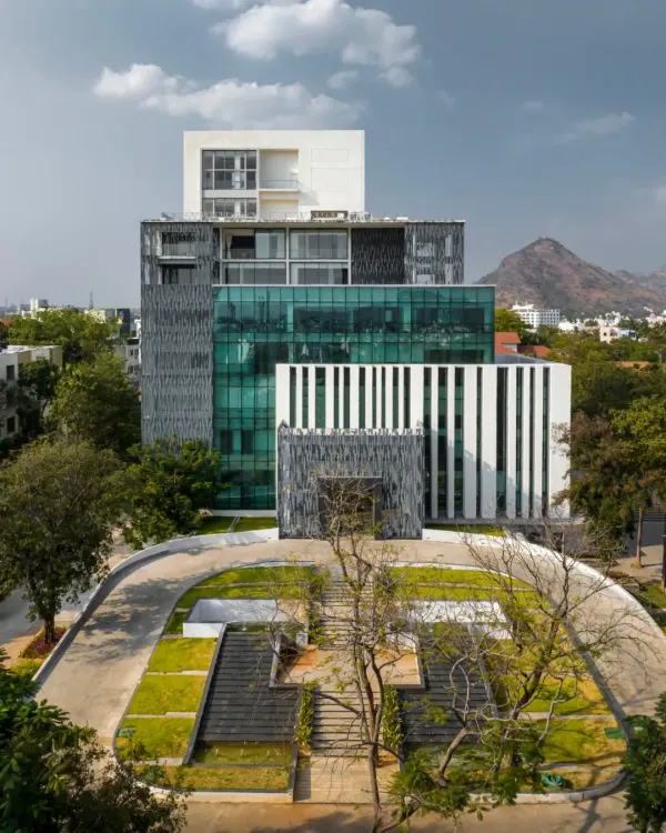 The Sona University Library is conceived as a vertical campus, with a striking facade of glass, stone, and jali screens. The design stacks diverse functions, from the library and auditorium to residential floors, creating a vibrant academic and cultural hub for the university.