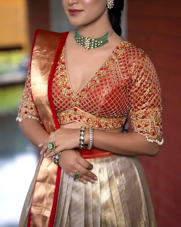 A close-up of a bridal blouse with a stunning V-neck and intricate jaal (net) embroidery. The floral motifs on the border add a touch of timeless elegance.