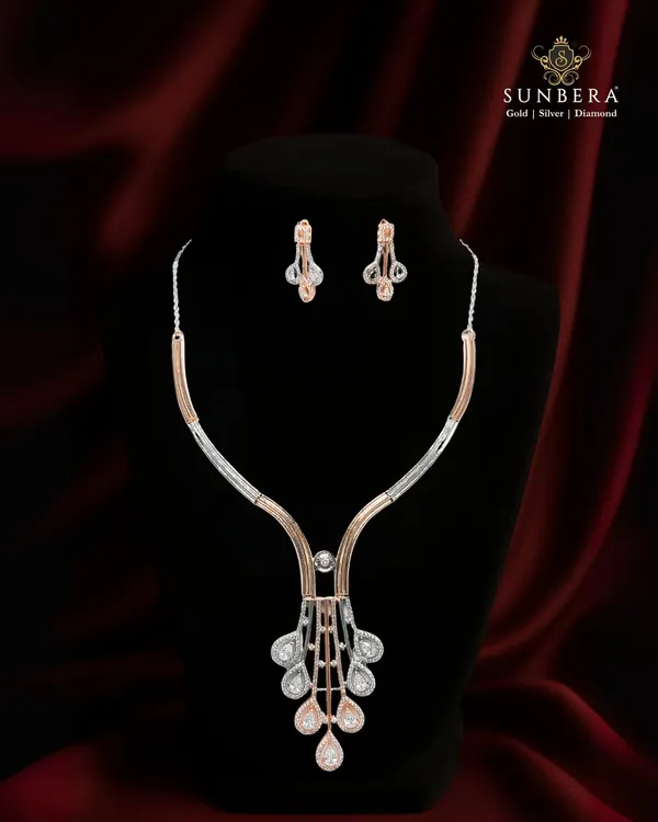 This stunning necklace set blends the cool shine of diamonds with the warm glow of rose gold. The modern, geometric pendant and matching earrings create a sophisticated look for any elegant evening.