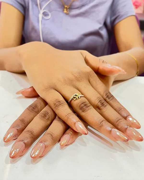 A beautiful example of ombre chrome nails. The color subtly shifts from a light, pearly base to a soft nude tip, creating a seamless and glowing effect.