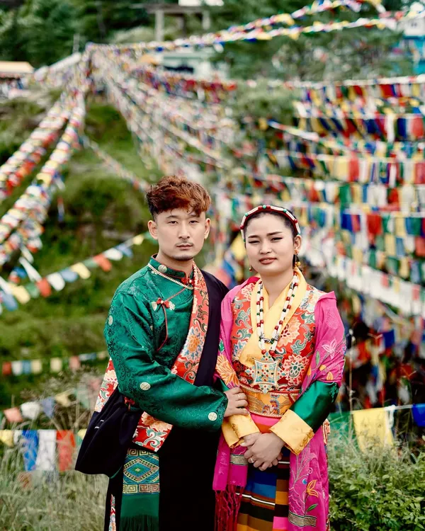 A classic portrait of a couple in traditional Kinnauri or Tibetan attire. The intricate details of their clothing and the direct gaze create a powerful and culturally rich image.