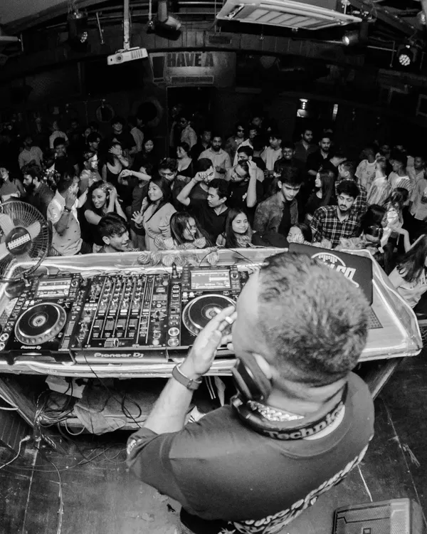 A fisheye view from the DJ console at Nuts & Brew in Guwahati. This shot puts you right in my shoes, looking out at a packed club ready for a banger of a night.