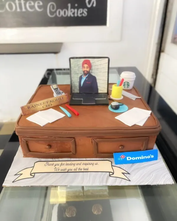 This farewell cake for the CEO of Domino's is a prime example of my detailed sculpting work. The entire office desk scene, including the laptop, papers, and even a miniature Starbucks cup, is handcrafted and edible.