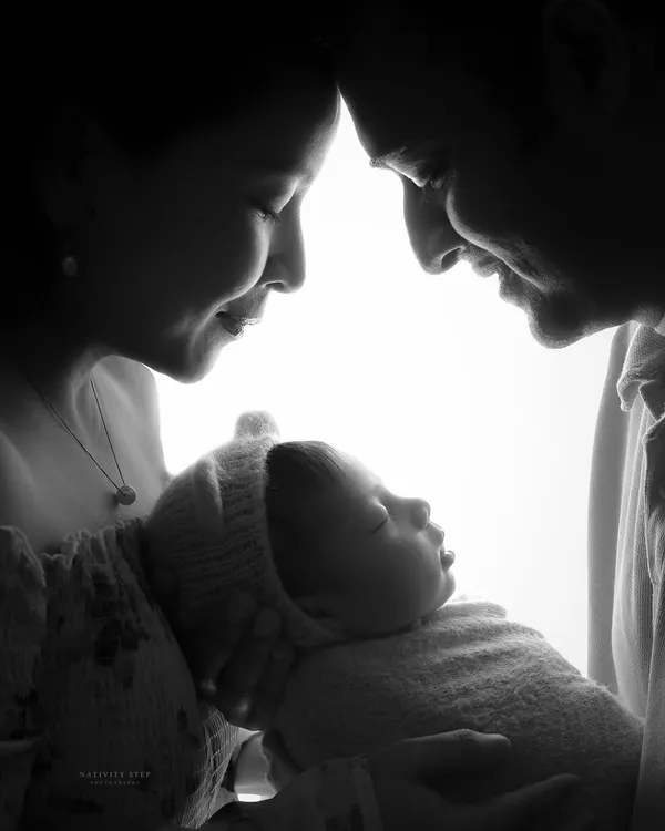 This is the moment it all begins. We use dramatic lighting to create this timeless silhouette portrait, focusing purely on the profound connection between new parents and their baby. It’s an artistic and emotional photograph that captures the love that fills the room.