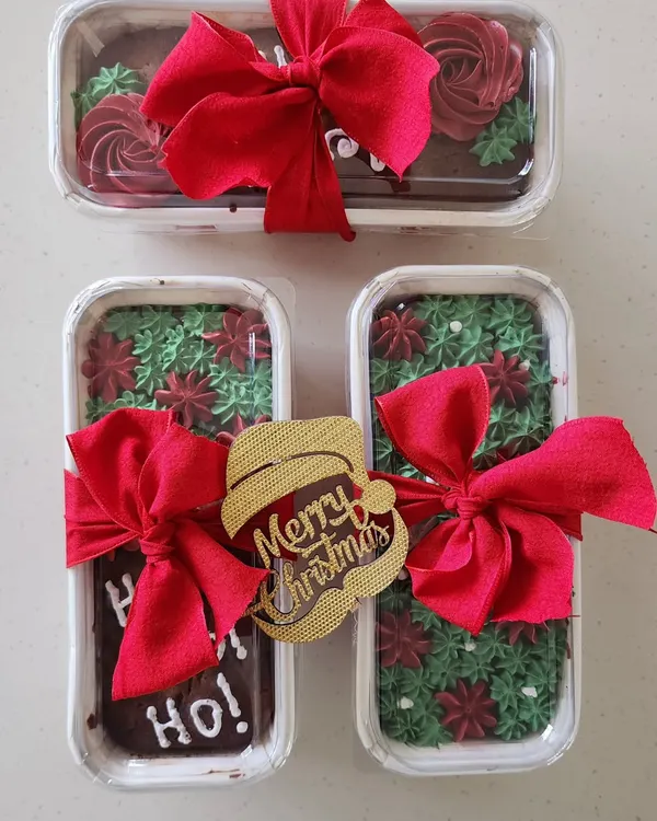 My Christmas rum cake loaves, all packed and ready for gifting. I decorate them with festive red and green icing and tie them with a bow and a "Merry Christmas" tag.
