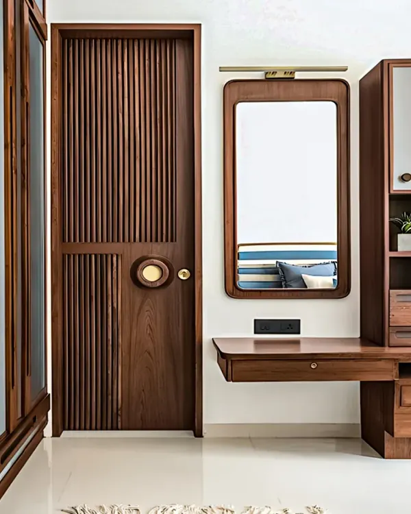 This image details our custom woodwork, showing a fluted wooden door and a matching dressing unit. The integrated design creates a cohesive and high-end look while providing practical storage.