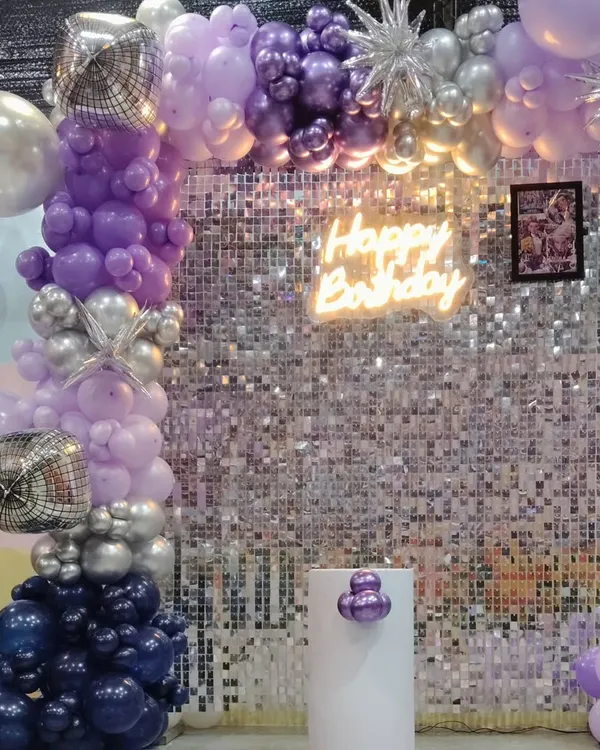 This is one of my most requested setups, perfect for a chic and modern birthday party. I create a full balloon arch using a mix of purple, navy, and silver balloons, including shiny disco balls for extra flair. The look is completed with a silver sequin wall and a custom "Happy Birthday" neon sign, creating a perfect photo booth area.