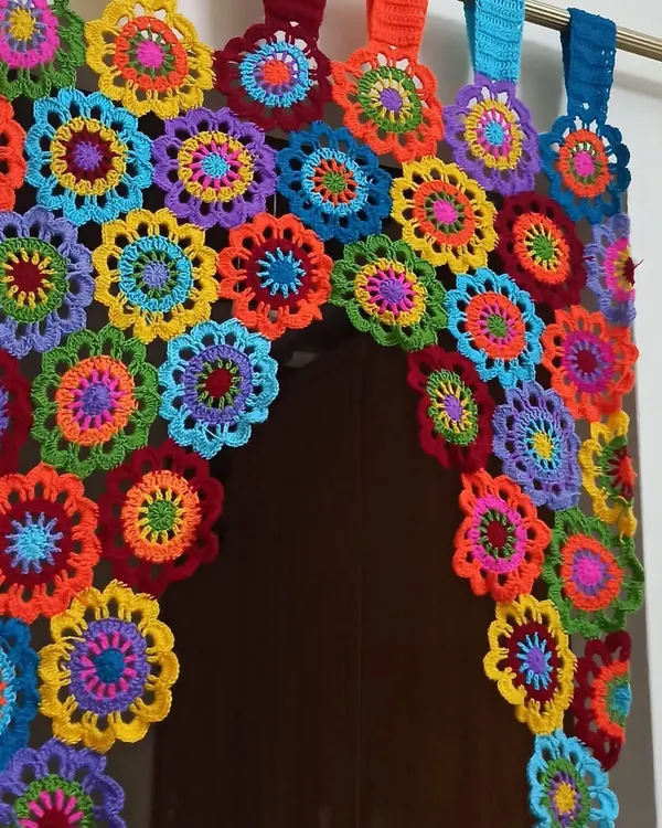 This vibrant, multi-colored floral curtain is one of my favorite statement pieces to make. Each flower is crocheted individually and then joined to create a beautiful arched valance that brings so much joy and color to a doorway or window.