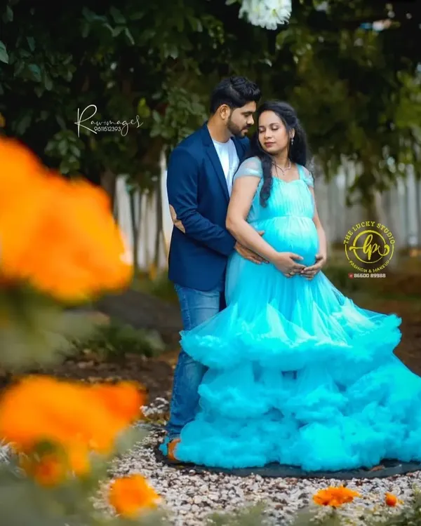 A beautiful maternity moment captured in a garden. I provided this stunning ruffled sky-blue gown and styled the couple for a memorable and romantic pregnancy photoshoot.