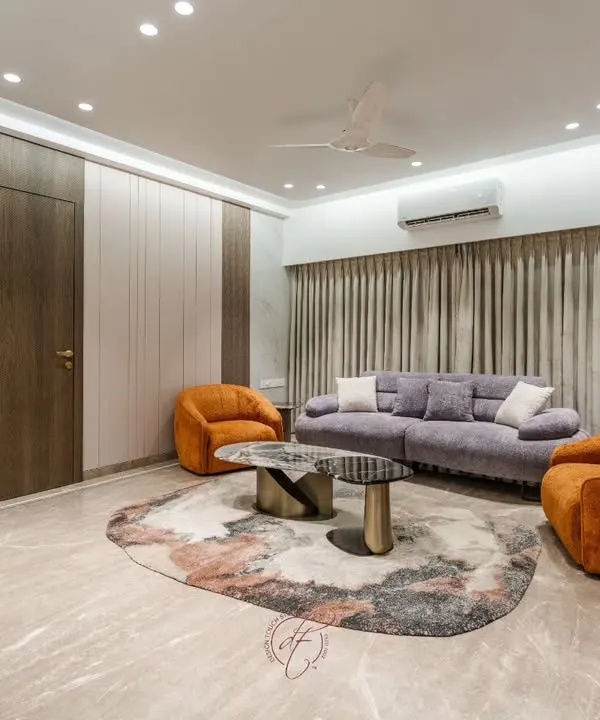 This living room is a masterclass in using color. We paired a soft lilac sofa with bold, burnt-orange swivel chairs to create a warm and inviting space, grounded by an abstract rug and Italian marble flooring.