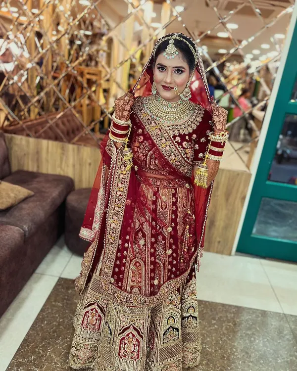 Our bride looks absolutely regal in a classic red and gold velvet lehenga. We focused on creating a timeless look with bold red lips, defined eyes, and traditional jewelry, ensuring she was picture-perfect for her wedding ceremony.