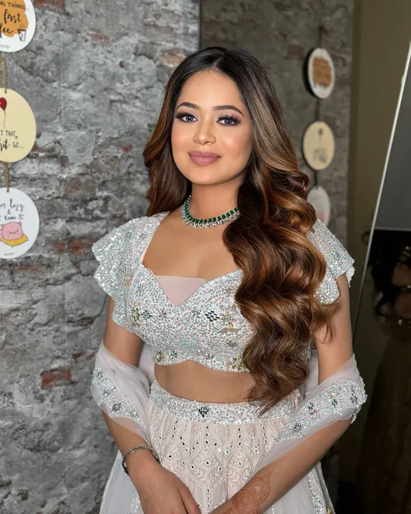 A perfect Roka look with soft, bouncy waves and beautiful highlights. This open hairstyle is glamorous yet effortless, ideal for a first wedding function.