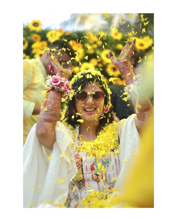 Pure joy and celebration! This bride is showered with yellow flower petals during her Haldi ceremony, and her happy, carefree expression says it all. These are the candid moments I love.