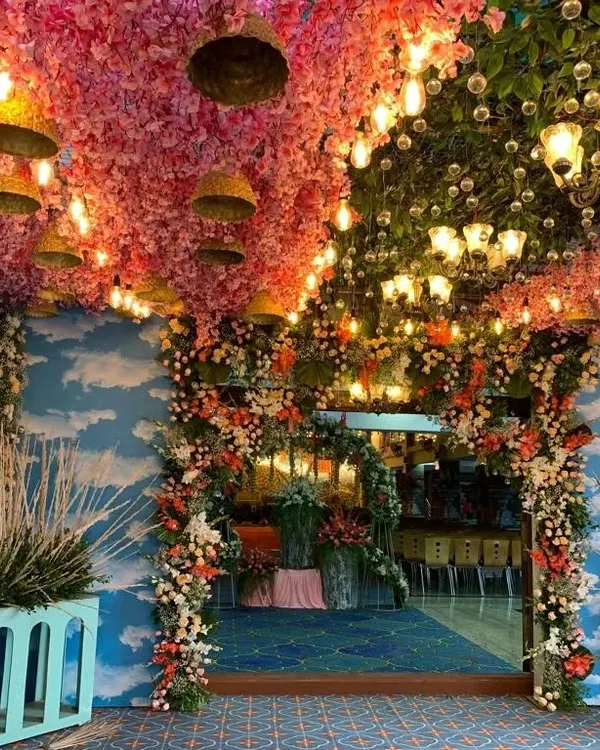 I specialize in creating breathtaking entrances for large-scale events. This grand naming ceremony decor features a ceiling covered in pink blossoms and intricate lighting to welcome guests into a magical space.