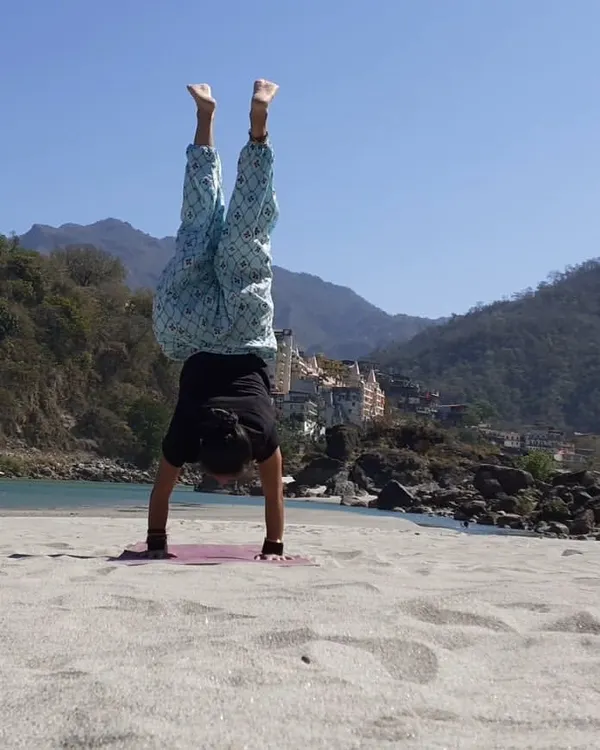 Yoga on the beach. A handstand on the sand in Rishikesh, feeling the energy of the earth and the sky.