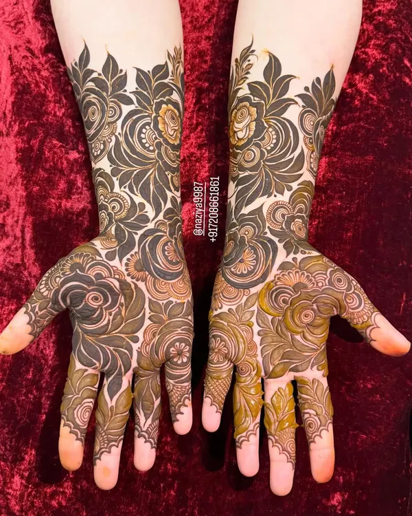 A beautiful example of a full-coverage floral design, combining dark-filled leaves with finely detailed flowers. This style is perfect for anyone who wants a rich and traditional henna look.