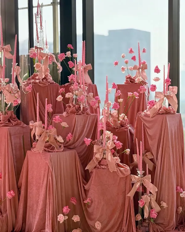 An absolutely breathtaking bridal shower, where the entire space is draped in luxurious blush pink velvet and adorned with pink candles and flowers.