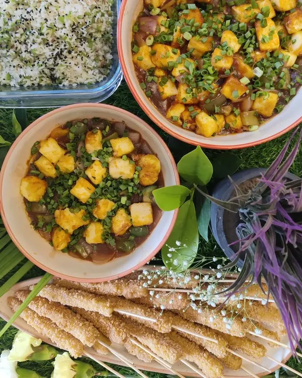 An Asian-inspired meal featuring Ginger Capsicum Fried Rice, Tofu in Black Bean Sauce, and crispy Baby Corn Skewers.