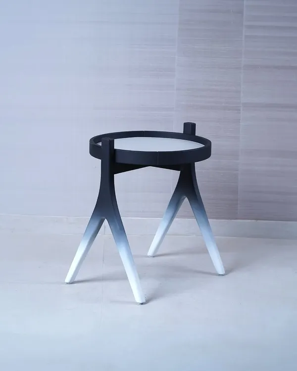 We designed this side table to be a piece of functional sculpture, featuring a striking black-to-white gradient on its tripod legs. Its minimalist form and unique finish make it a modern accent piece that adds an artistic touch to a space.