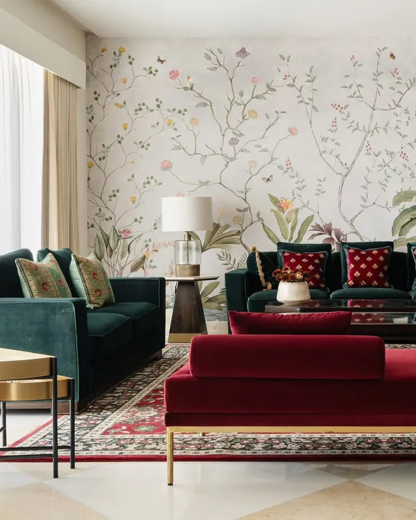 A full view of a living room featuring my floral garden mural. The design serves as a soft, artistic backdrop that unifies the space and complements the rich jewel tones of the furniture.