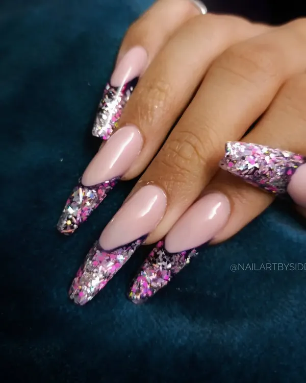 A dramatic and glamorous look, these long nails feature a French-style design with tips made entirely of chunky, holographic pink and silver glitter.