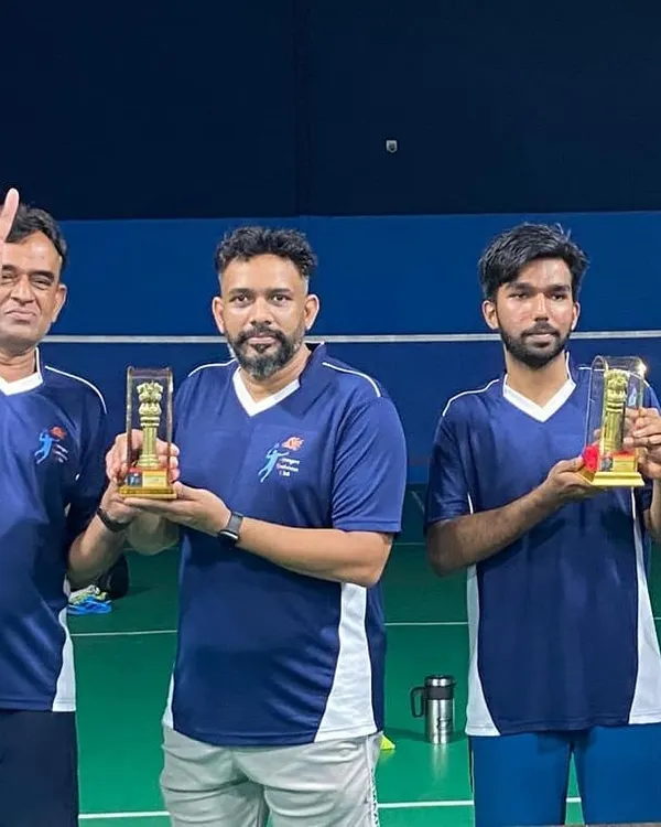 Three proud members of the winning team holding their well-deserved trophies.