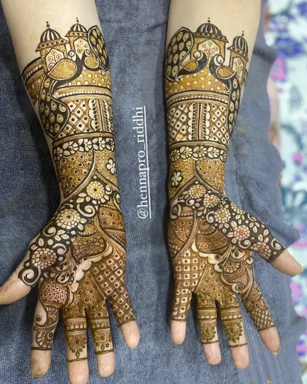 This is a 3/4 length design, perfect for brides who want significant coverage without going all the way up the arm. It features beautiful peacocks and architectural dome elements.