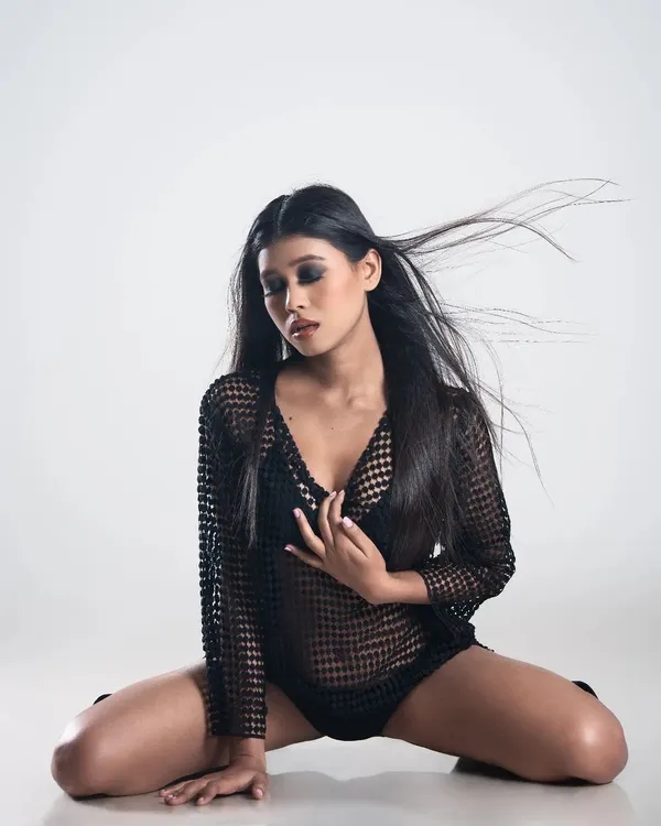 A powerful pose from a studio fashion shoot. The makeup features a dark, intense smoky eye and a contoured base, designed to look striking and last under professional studio lighting.