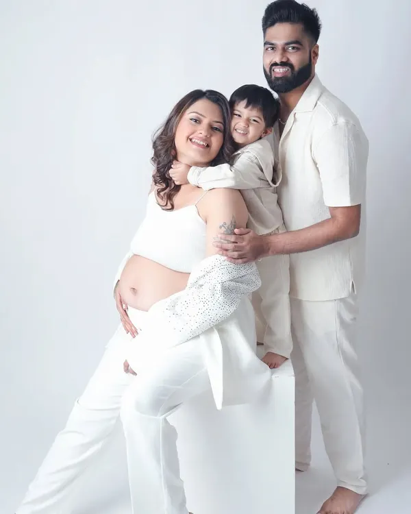 A beautiful family portrait filled with love and joy. The older sibling gives his mom a big hug, excited to become a big brother.