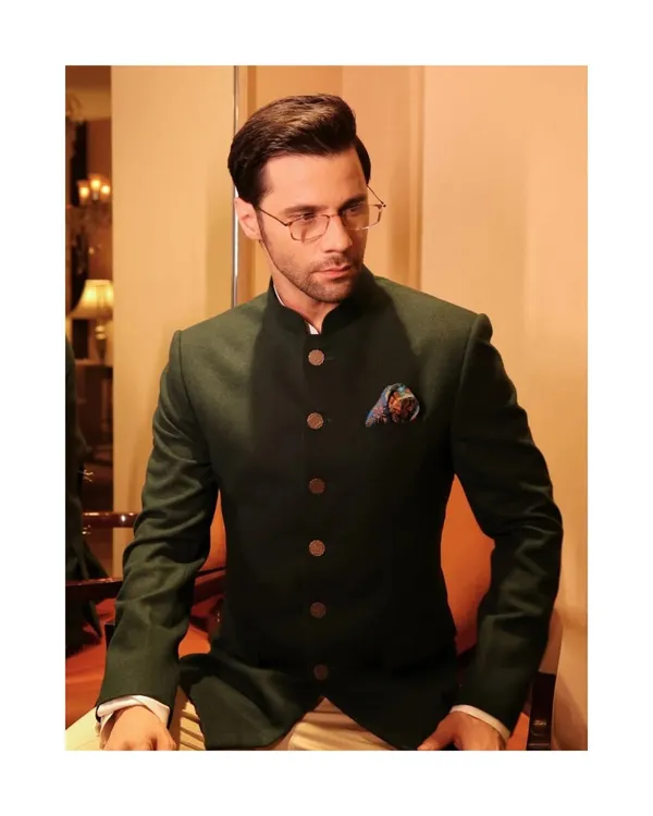 A perfect example of our Indo-Western style. This dark green bandhgala jacket, paired with light trousers, is finished with unique buttons made from antique 1 Anna coins.