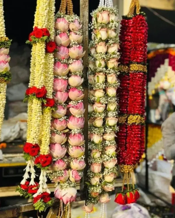 I specialize in creating all types of fresh flower garlands. This photo shows some of my premium garlands, including ones made with lotus buds, roses, and jasmine, perfect for the bride and groom or for decorating deities.