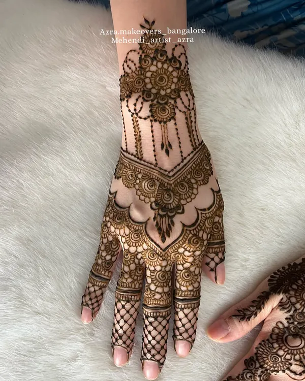 An elegant and sophisticated design for the back of the hand, featuring delicate chains and a central motif. Perfect for a wedding guest.