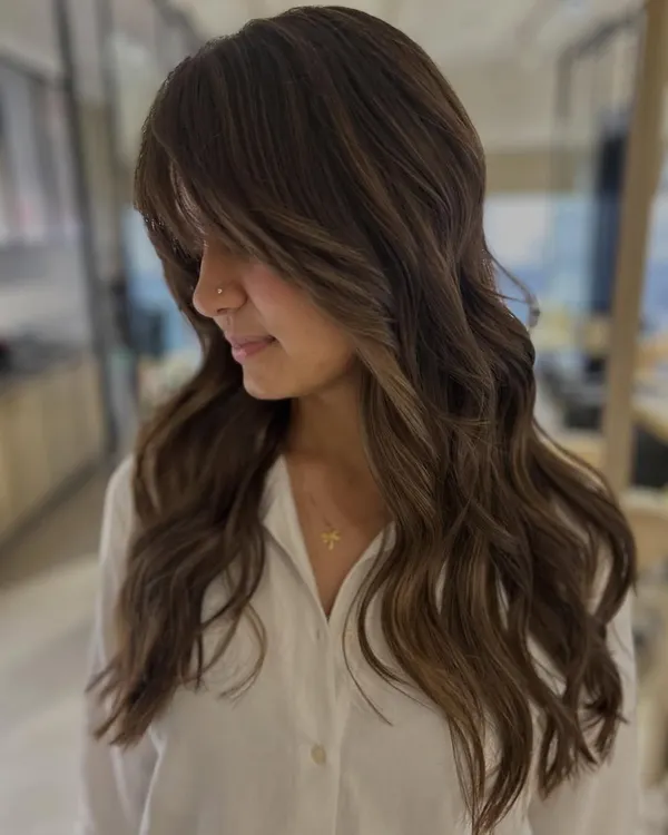 This client's first-ever hair color, and we did it without any bleach. The three-tone color and face-framing layers create a beautiful, subtle transformation.