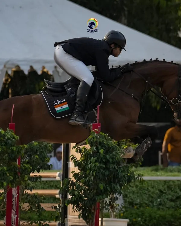 A moment of pure focus and athleticism. This shot captures the powerful partnership between horse and rider as they navigate a challenging course, a hallmark of our advanced show jumping program.