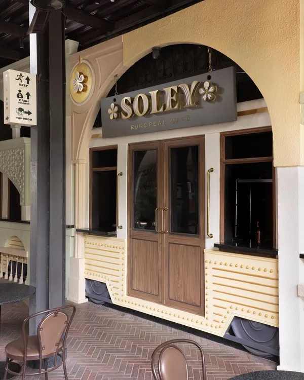 The entrance to Soley European Cafe, where a custom-built tram car facade serves as a unique gateway to the culinary experience inside. This design element immediately transports visitors and sets the narrative for the space.